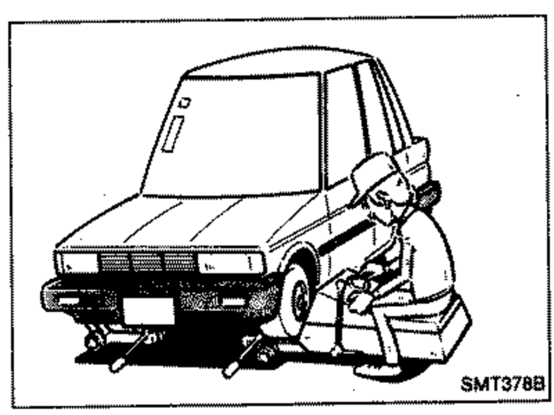 Front three-quarter view of a vehicle raised on stands with an on-the-car wheel balancer positioned at the front wheel. Illustrates mounting the wheel to be balanced onto the balancer.