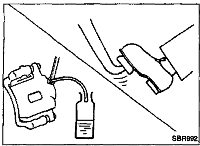 Brake caliper / bleeder valve with a hose attached to a bleeder valve draining brake fluid into a container.