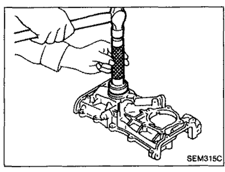 Illustration of installing a new front oil seal into the front cover using a suitable tool/drift. A hand holds the tool positioned over the seal bore of the front cover.