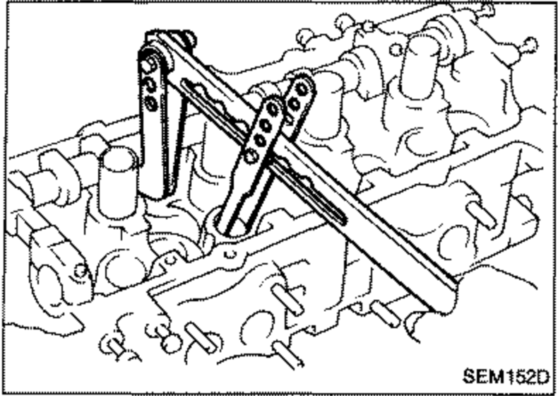 Illustration of removing valve components from the cylinder head using a special tool (valve spring compressor). The lever-type tool is positioned over a valve on the head.