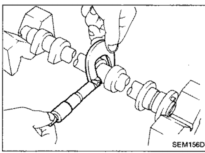 Illustration of measuring the outer diameter of a camshaft journal using a micrometer.