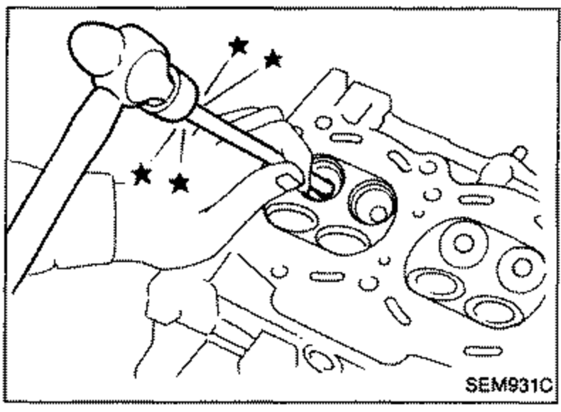 Illustration of driving out the valve guide using a press or hammer and suitable tool/drift on the cylinder head; stars/arrows mark the guide locations.