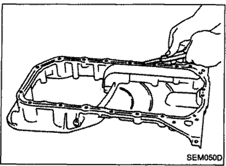 Removing traces of old liquid gasket from the aluminum oil pan mating surface using a scraper.