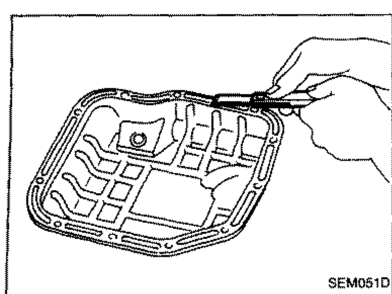 Removing traces of old liquid gasket from the steel oil pan mating surface using a scraper.