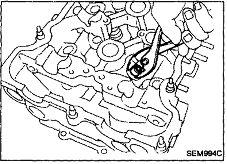 Cylinder head valve area showing removal of the valve oil seal, illustrating the location of the seal on the valve guide.