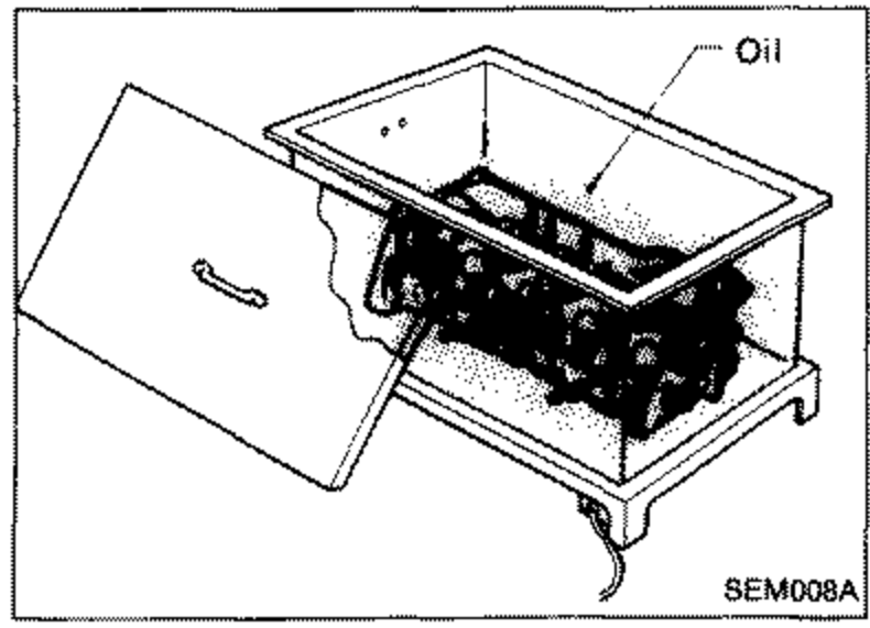Illustration showing a cylinder head being heated in a container of oil for valve guide replacement, label 'Oil'.