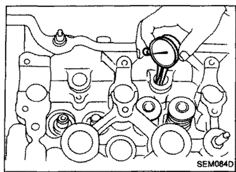 Illustration showing a dial bore gauge measuring lash adjuster guide inner diameter in the cylinder head.