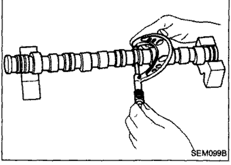 Hand using a micrometer to measure the outside diameter of a camshaft journal.
