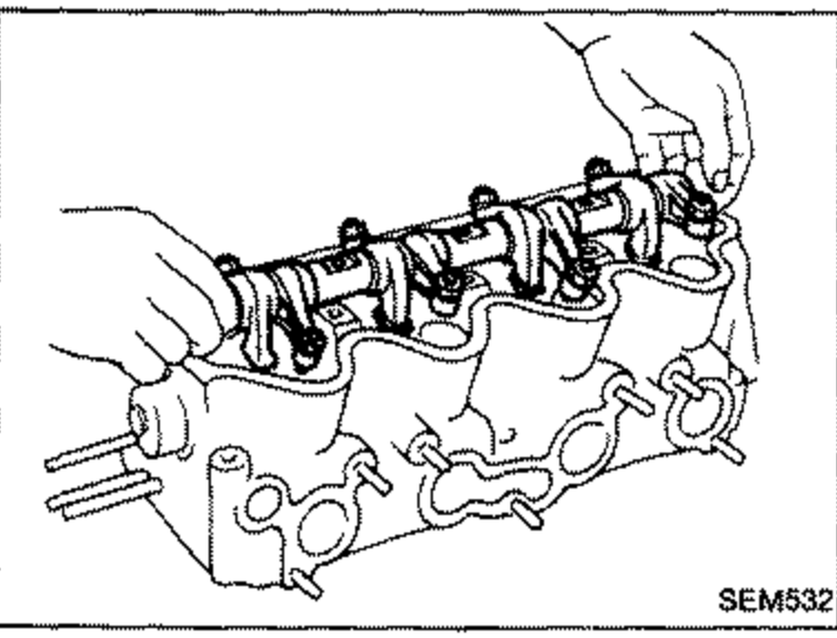 Rocker shaft with rocker arms being installed on the cylinder head.