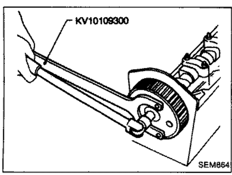 Tool KV10109300 engaged on a camshaft sprocket to hold/remove the front camshaft sprocket plate and front and rear sprockets.