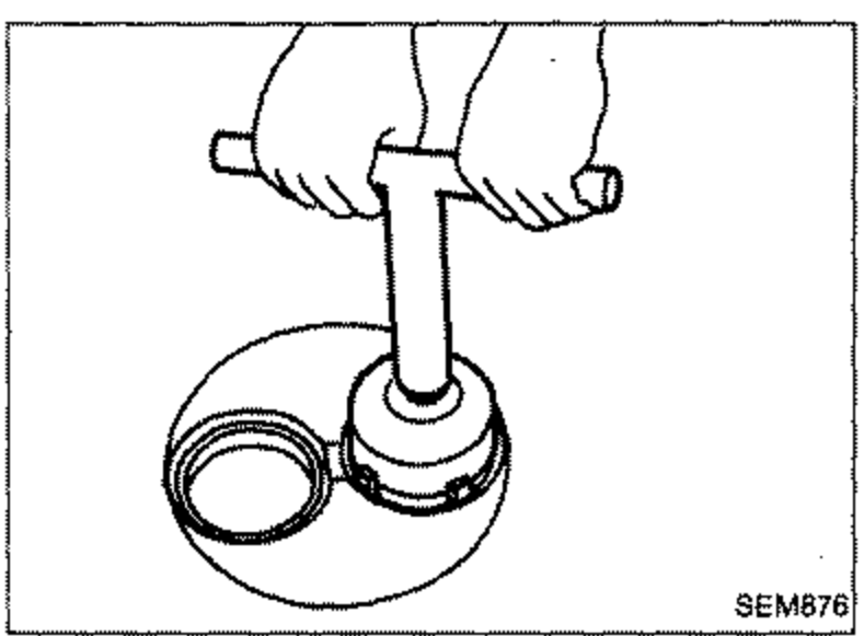 Hands using a cutting tool to cut or grind a valve seat in the cylinder head recess.