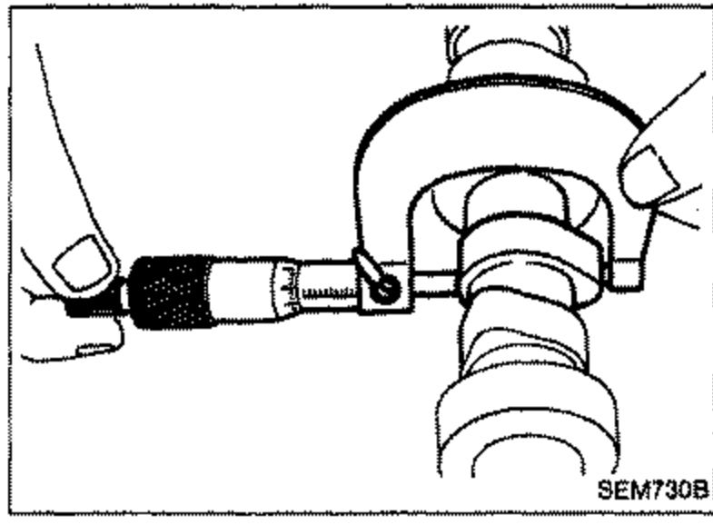 Micrometer measuring the cam lobe height of a camshaft.