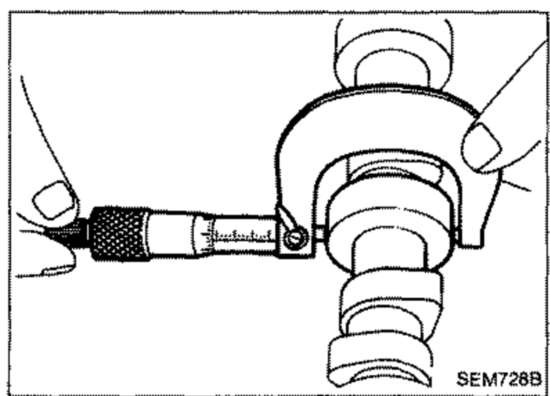 Micrometer measuring the outer diameter of a camshaft journal.