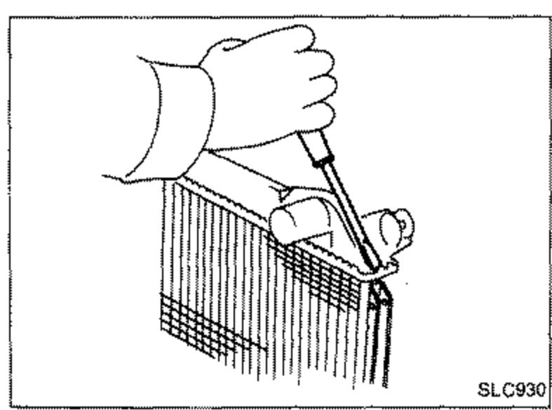 Illustration of a hand using a screwdriver to bend the crimped edge of the radiator core up in an area where the special tool cannot be used.
