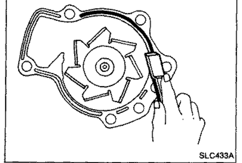 Removing traces of liquid gasket from the water pump mating surface using a scraper.