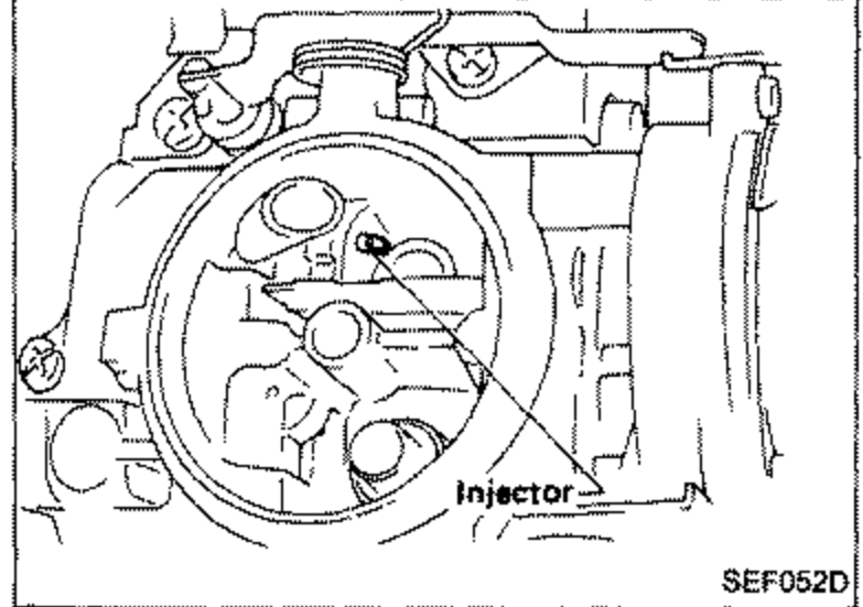 Carburetor throat view showing the injector located at the primary port; arrow indicates fuel injection point.