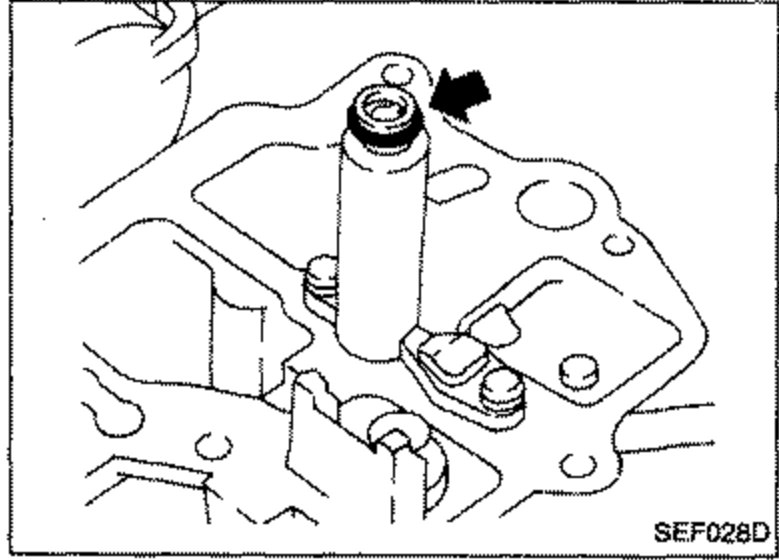 Close-up of choke chamber assembly with a downward arrow indicating installation of the choke chamber.