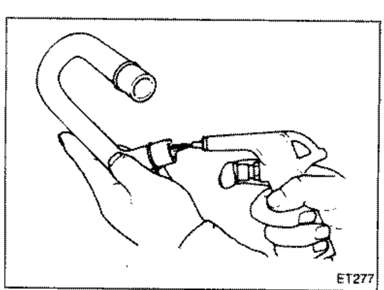 Illustration of a hand holding an air blow gun connected to a ventilation hose, cleaning the hose with compressed air. The curved ventilation hose is shown at top.
