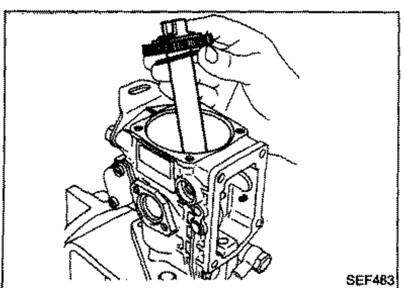 Drive shaft being removed vertically from the fuel injection pump body, held by a hand.