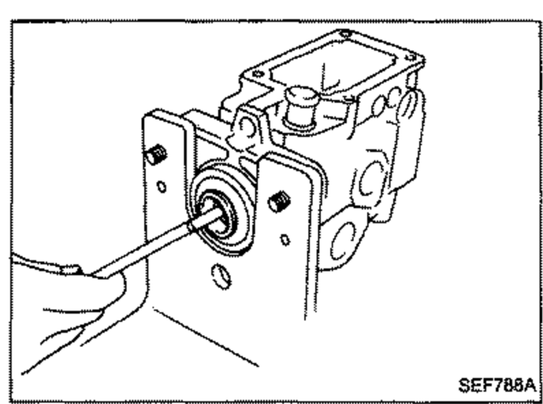 Oil seal being removed from the pump body using a hooked tool inserted from the left.