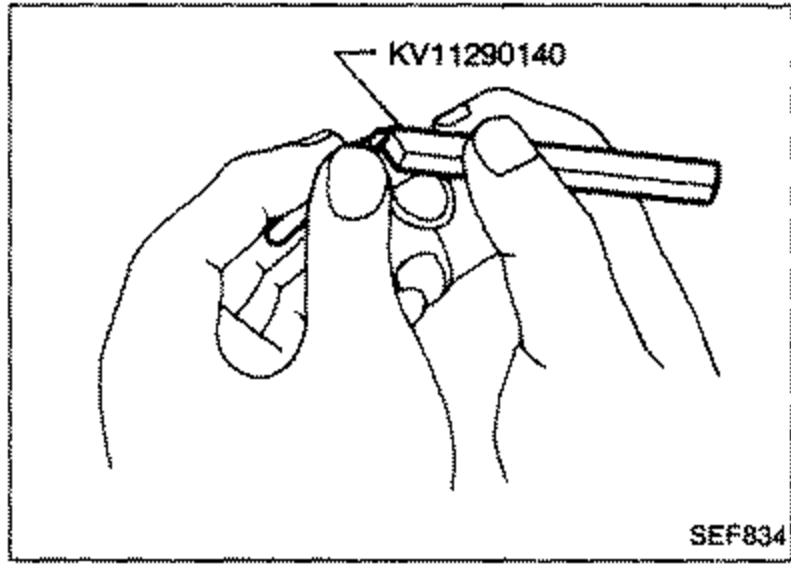 Illustration of hands using special tool KV11290140 to decarbonate the nozzle needle tip.